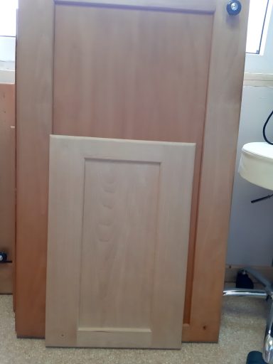 Küchenmöbel Holztüren in zwei Größen, eine größere und eine kleinere, auf einem Tisch angelehnt.